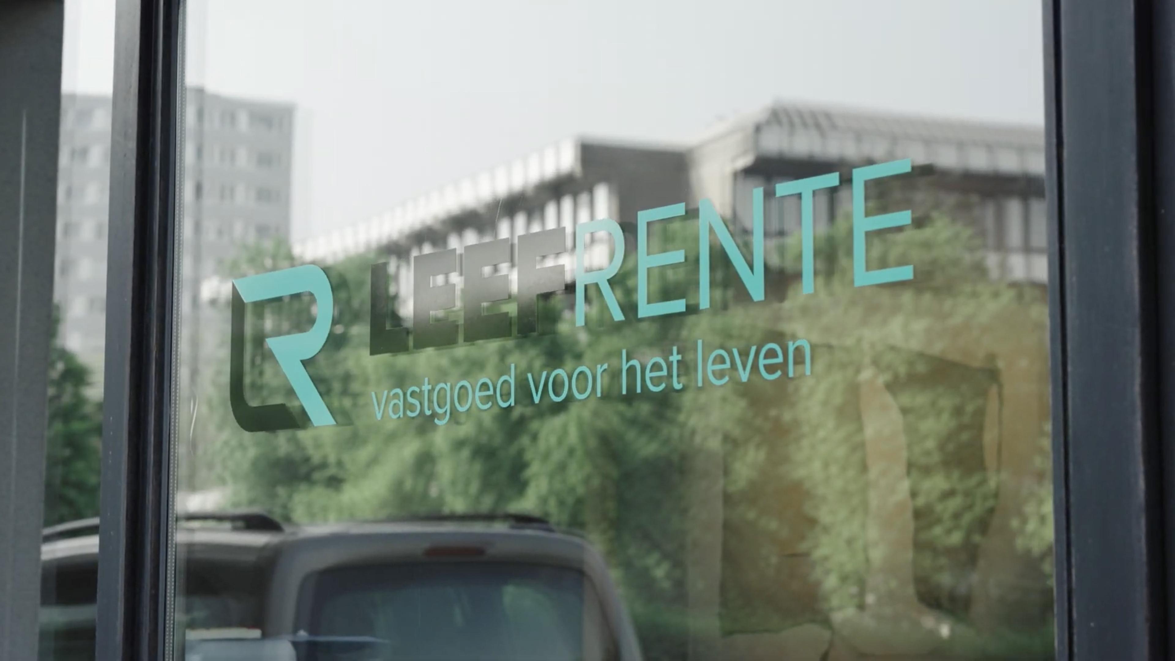 Leefrente-logo op kantoorraam met weerspiegeling van groene omgeving